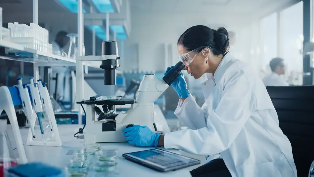 Female scientist examining a sample under microscope